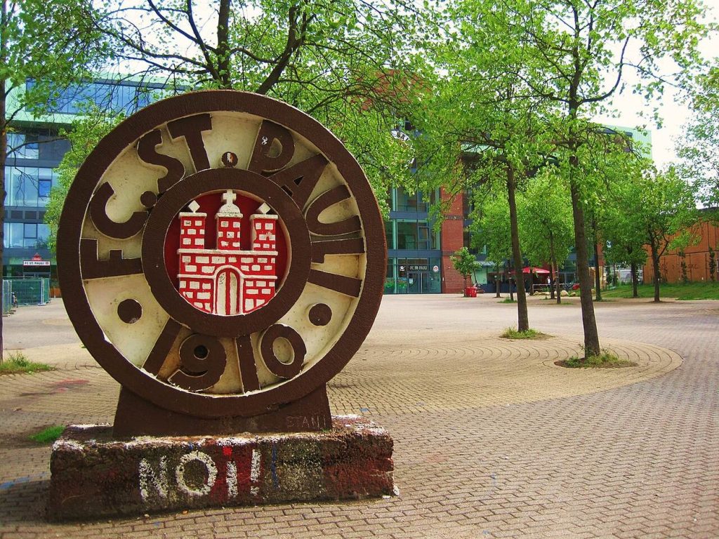 ประติมากรรมวงกลมสลักตราสโมสร FC ST. PAULI 1910 ตั้งอยู่กลางลานหินปูนใต้ต้นไม้ใกล้สนามมิลเลิร์นทอร์